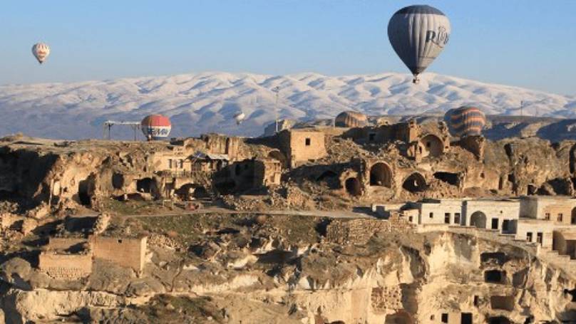 Cappadocia with hot air balloons flying around the sky