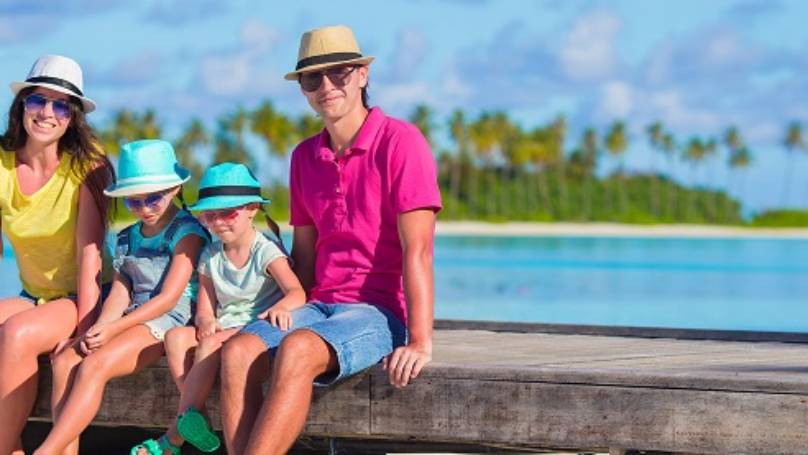 Family relaxing sitting near beach and sea on their summer holiday