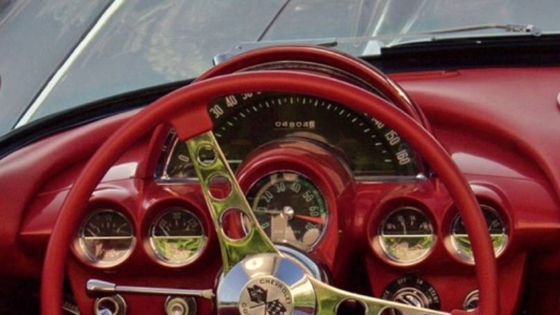 Vintage Chevrolet Corvette red dashboard with red steering wheel with chrome trims