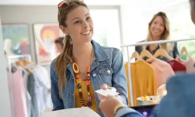 a customer smiling and handing over a credit card