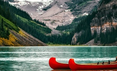 Canadian kayaks in water surrounded by Canadian mountains and trees